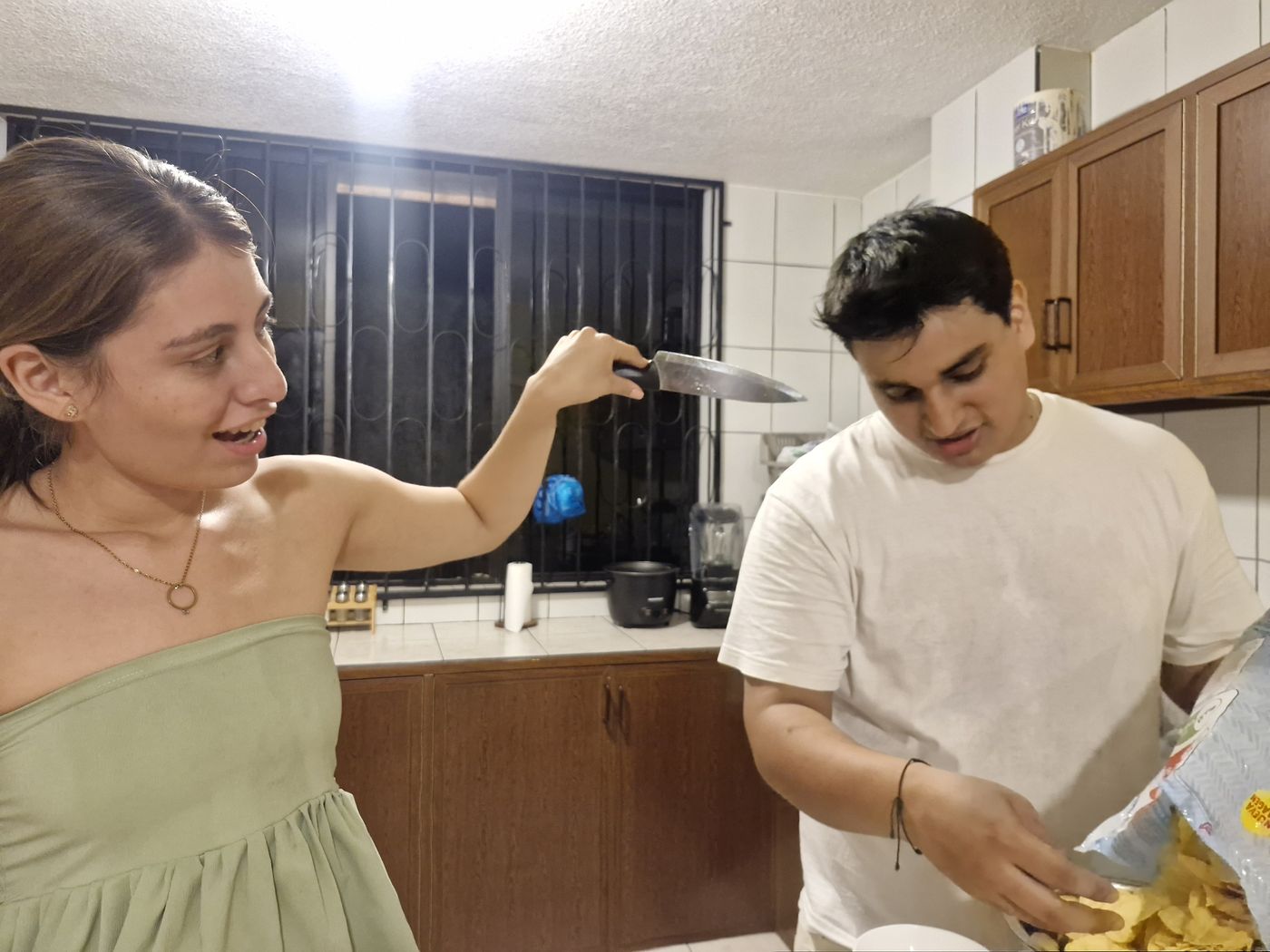 En la cocina, preparando algo de comer.
